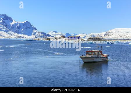 Bateau ancré dans le lagon et l'ancien village de pêcheurs de Qoornoq au milieu du fjord de Nuuk, au Groenland Banque D'Images