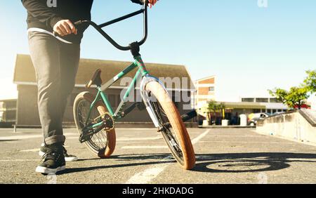 Dans la rue.Coupe courte d'un cycliste BMX masculin méconnaissable à l'extérieur. Banque D'Images