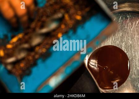 Une liqueur de cacao fraîche s'écoule d'une machine à moulin dans la fabrication artisanale de chocolat à Xochistlahuaca, Guerrero, Mexique. Banque D'Images