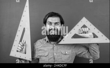 homme heureux avec la taille mesurée sur l'outil de mathématiques de règle de triangle, école de mathématiques Banque D'Images