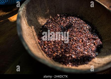 Des fèves de cacao concassées grossièrement concassées sont déposées dans un bol de la fabrication artisanale de chocolat à Xochistlahuaca, Guerrero, Mexique. Banque D'Images