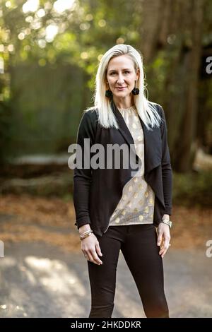 Une belle femme blonde de buisness dans ses années trente dehors dans un fond naturel avec l'espace de copie Banque D'Images