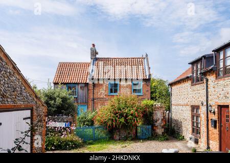 Scène de rue avec des cottages de style local à l'ancienne à CLEY-Next-the-Sea, un village côtier sur la côte nord de Norfolk, East Anglia, Angleterre Banque D'Images