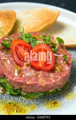 Plat de tartare frais avec tomates sur une assiette Banque D'Images