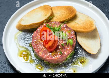 Plat de tartare frais avec tomates sur une assiette Banque D'Images