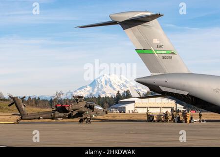 Des soldats affectés à D co., 1-229th Bataillon d'attaque, 16th Brigade de l'aviation de combat déchargent un hélicoptère AH-64E Apache d'un C-17 Globemaster affecté à la 62nd escadre de transport aérien de l'aérodrome de l'Armée Grey, base interarmées Lewis-McChord, Washington, le 28 janvier 2022.Le soldat s'était formé avec les aviateurs sur les procédures de chargement et d'arrimage des hélicoptères pour rester prêt pour les opérations de combat expéditionnaires.(É.-U.Photo de l'armée par le capitaine Kyle Abraham, 16th Brigade de l'aviation de combat) Banque D'Images