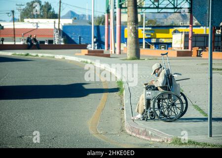 Un mexicain en chaise roulante passe ses journées à ramasser des déchets le long des gouttières des rues de Puerto Penasco, Sonora, Baja California, Mexique. Banque D'Images