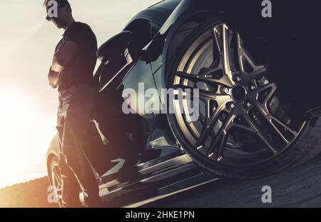 Caucasiens hommes dans son 40s et sa nouvelle Super voiture.Paysages pittoresques au coucher du soleil.Thème automobile. Banque D'Images