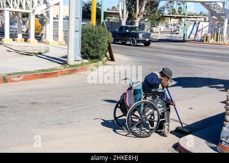 Un mexicain en chaise roulante passe ses journées à ramasser des déchets le long des gouttières des rues de Puerto Penasco, Sonora, Baja California, Mexique. Banque D'Images