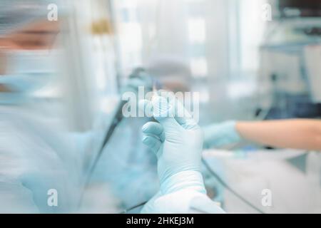 L'équipe médicale fournit la procédure endoscopique au patient en unité de soins intensifs, en arrière-plan non focalisé. Banque D'Images