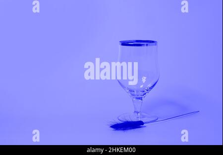 Un verre de vin vide et un bouquet de fleurs lagurus séchées Banque D'Images