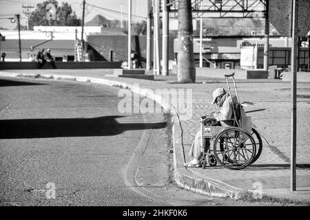 Un mexicain en chaise roulante passe ses journées à ramasser des déchets le long des gouttières des rues de Puerto Penasco, Sonora, Baja California, Mexique. Banque D'Images