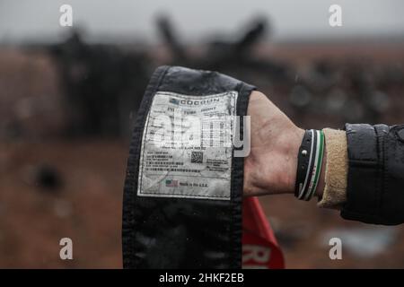 Afrin, Syrie.04th févr. 2022.Un homme porte un épave de la ceinture de sécurité du pilote d'un hélicoptère américain qui a été soufflé par les forces spéciales américaines après avoir été confronté à des problèmes mécaniques et qui n'était plus opérationnel.Le broyeur MH-60 Black Hawk a participé à un raid dans la ville d'Atmeh qui a entraîné la mort du chef de l'EI Abu Ibrahim al-Hashimi al-Qurayshi.Les responsables américains nient qu'il s'est écrasé ou qu'il a été abattu.Credit: Aras Alkharboutli/dpa/Alamy Live News Banque D'Images