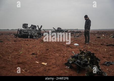 Afrin, Syrie.04th févr. 2022.Un homme se tient pour le compte d'un hélicoptère américain qui a été soufflé par les forces spéciales américaines après avoir été confronté à des problèmes mécaniques et qui n'était plus opérationnel.Le broyeur MH-60 Black Hawk a participé à un raid dans la ville d'Atmeh qui a entraîné la mort du chef de l'EI Abu Ibrahim al-Hashimi al-Qurayshi.Les responsables américains nient qu'il s'est écrasé ou qu'il a été abattu.Credit: Aras Alkharboutli/dpa/Alamy Live News Banque D'Images