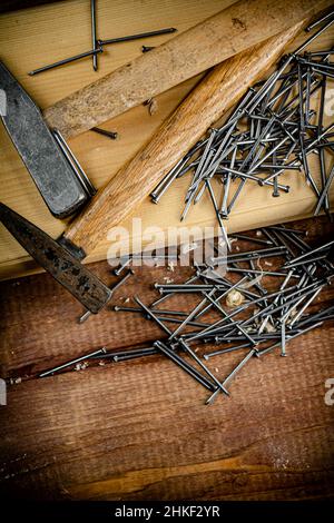 Frapper avec un tas de clous sur la table.Sur fond en bois.Photo de haute qualité Frapper avec un tas de clous sur la table.Sur fond en bois.Photo de haute qualité