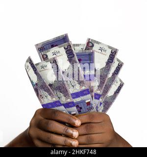Main noire tenant 3D rendu 500 billets riyal Qatar. gros plan des mains tenant des billets de monnaie qatari Banque D'Images