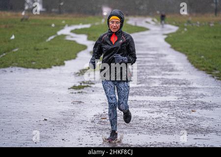 WIMBLEDON LONDRES, ROYAUME-UNI.4th févr. 2022.Une femme qui fait du jogging sur Wimbledon Common, dans le sud-ouest de Londres, sous la pluie verglaçante froide, alors que le bureau met prévoit une baisse des températures et un « moment de sommeil » pour le sud-ouest de l'Angleterre ce soir crédit : amer ghazzal/Alay Live News Banque D'Images
