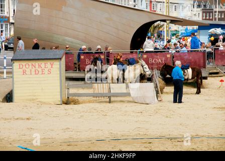 Des promenades à dos d'âne sur la plage, Weymouth, Dorset, Angleterre où les affaires sont lentes Banque D'Images