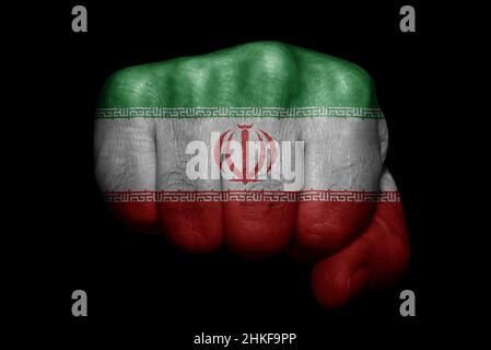 Drapeau de l'Iran peint sur un poing fort sur fond noir Banque D'Images