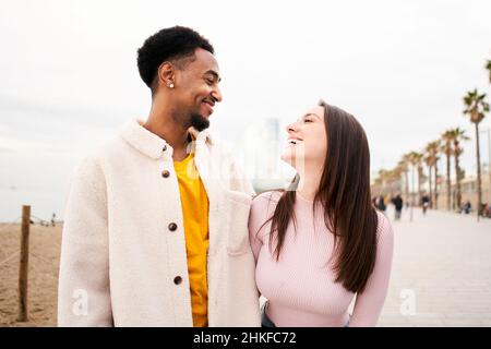 Jeunes couples multiraciaux amoureux de s'amuser ensemble en plein air sur la plage de la ville. Banque D'Images