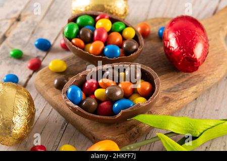 Les oeufs de Pâques en chocolat coloré sur table en bois Banque D'Images