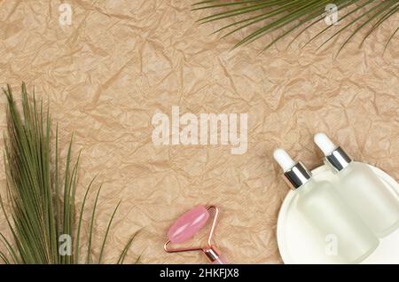 Arrière-plan de papier sulfurisé pour la publicité de cosmétiques.Flacons à huile et masseur pour le visage sur fond de papier froissé avec espace pour le texte Banque D'Images