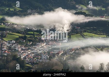 Vue panoramique sur le petit village de Furnas dans l'île de Sao Miguel (Açores, Portugal); la brume est causée par plusieurs fumaroles naturelles Banque D'Images