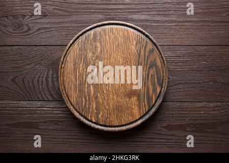 Planche à découper ronde avec rainure sur fond de table en bois, vue du dessus Banque D'Images