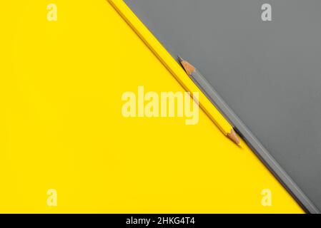 Crayon jaune et gris placé sur fond de papier jaune et gris avec espace de copie pour votre image ou votre texte Banque D'Images