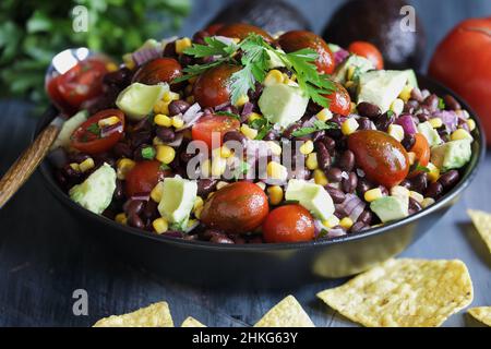 Salade mexicaine maison de haricots noirs et de maïs ou sauce au caviar de caviar de Texas, servie avec des chips de tortilla et des ingrédients frais. Banque D'Images