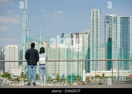 Jeune couple debout sur le pont et appréciant cityscane, vue de l'arrière Banque D'Images