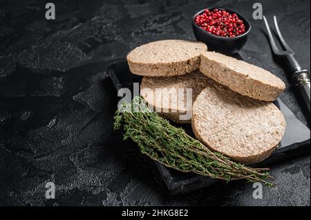 Côtelettes de burgers non cuites à base de viande végétale, viandes végétaliennes crues.Arrière-plan noir.Vue de dessus.Copier l'espace Banque D'Images