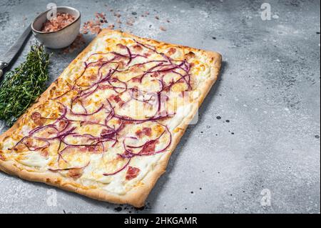 Tarte traditionnelle allemande de Flamkuchen avec jambon et oignon.Arrière-plan gris.Vue de dessus.Copier l'espace Banque D'Images