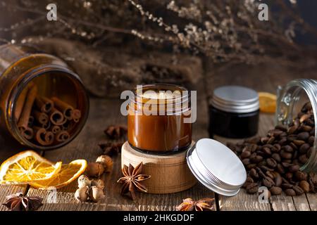 Bougie parfumée dans un pot en verre.Arôme du café.Anis étoilé, bâtonnets de cannelle, orange séchée.Encore la vie.Grains de café.Pots bruns avec bougies.Aromatherap Banque D'Images