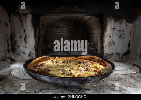 Délicieuses pizzas appétissantes cuites sur des coals dans un vieux four russe.Cuisine traditionnelle de campagne.Style de vie. Banque D'Images