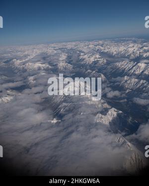 Vue sur les montagnes rocheuses enneigées du Canada entre l'Alberta et la Colombie-Britannique depuis le siège de fenêtre de l'avion lors d'hivers clairs vol de jour Banque D'Images