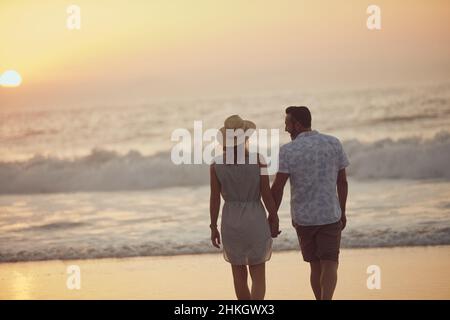 Dites que vous passerez toujours avec moiVue arrière d'un couple mature passant du temps de qualité sur la plage. Banque D'Images