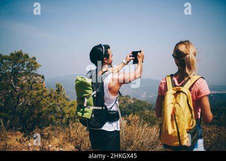 Hommes et femmes touristes debout sur la colline et prendre des photos Banque D'Images