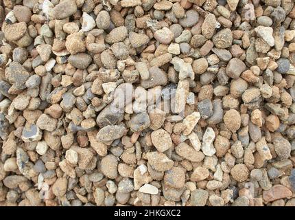 Une texture faite d'une pile de gravier de piste de course. Pierre aromatique, cailloux sur la plage, fond de pierre de roche Banque D'Images