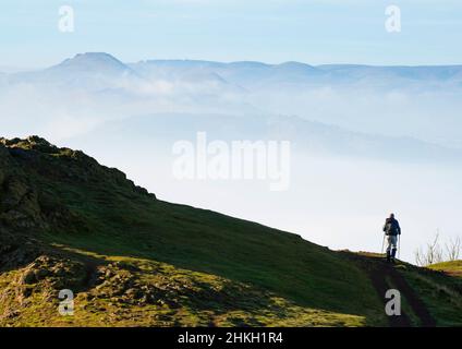 Un marcheur au sommet du Wrekin, avec les collines de Stretton à l'horizon, Shropshire. Banque D'Images