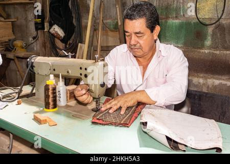 Un nicaraguayen travaille sur une machine à coudre industrielle dans son atelier de menuiserie et de sellerie à Jinotega, au Nicaragua. Banque D'Images