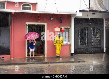 Deux personnes attendent sous le toit, espérant une pause dans la pluie de l'ouragan Iota à Jinotega, au Nicaragua. Banque D'Images