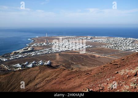 Vue sur faro et punta pechiguera depuis le sommet du volcan rouge montana roja éteint près de playa blanca Lanzarote Iles Canaries Espagne Banque D'Images