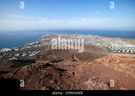 Vue sur faro et punta pechiguera depuis le sommet du volcan rouge montana roja éteint près de playa blanca Lanzarote Iles Canaries Espagne Banque D'Images