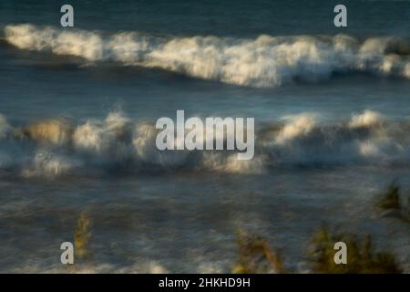 Les vagues du lac Ontario s'écrasant dans les vagues de surf du front de mer de plage avec des caps blancs bleu de l'eau sur le mouvement de jour ensoleillé causé par une exposition longue durée horizontale Banque D'Images