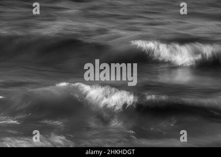 Les vagues du lac Ontario s'écrasant dans les vagues de surf du front de mer de plage avec des caps blancs bleu de l'eau sur le mouvement de jour ensoleillé causé par une exposition longue durée horizontale Banque D'Images