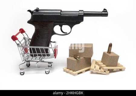 Gros plan du pistolet semi-automatique noir dans un petit chariot avec des palettes en bois et des munitions à côté de lui sur fond blanc concept de commerce de pistolet et Banque D'Images