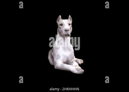 Un chien de la race Great Dane blanc est isolé sur fond noir. Figurine en porcelaine.Photo de haute qualité Banque D'Images