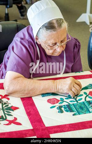 Sarasota Florida,Pinecraft Pine Craft,Alma Sue's Quilts,Amish Mennonite femme courtepointe citoyen se concentrant portant le kapp Banque D'Images