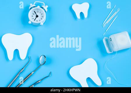 Maquette en papier de dent et d'instrument dentaire sur fond bleu.Concept de soins dentaires.Journée internationale des dentistes.Carte de vœux pour les vacances professionnelles Banque D'Images